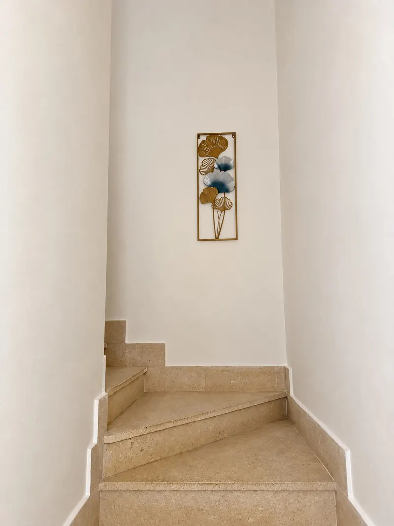 La scala interna in marmo, con un quadro alla parete