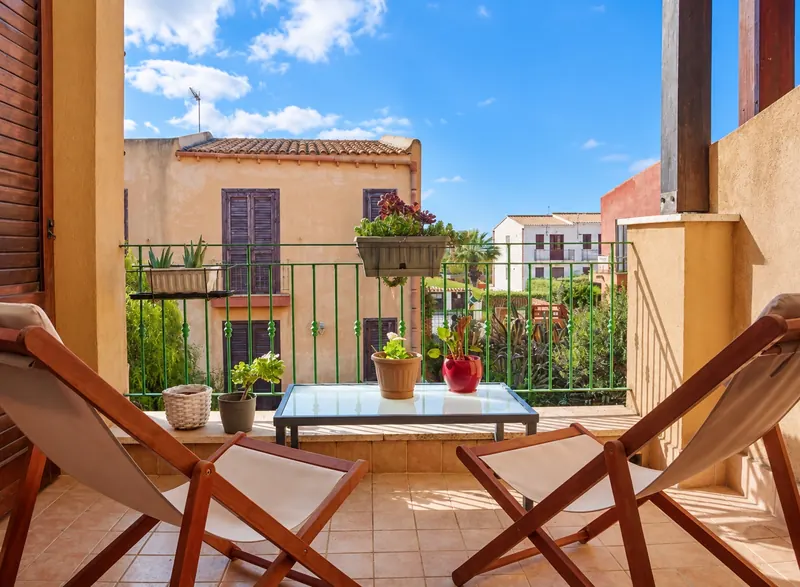 Il balcone con due sdraio in legno, il tavolino e i fiori
