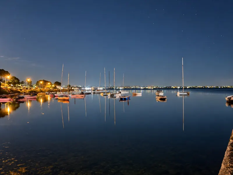 Il porticciolo di notte, con le barche e le luci riflesse sull'acqua