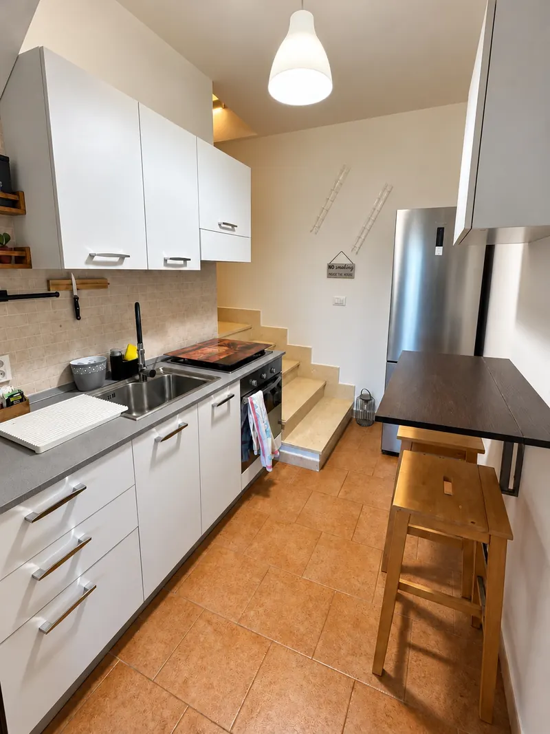 La cucina vista dall'ingresso, con il frigorifero e la scala
